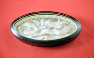 oval wooden and glass box containing locks of hair